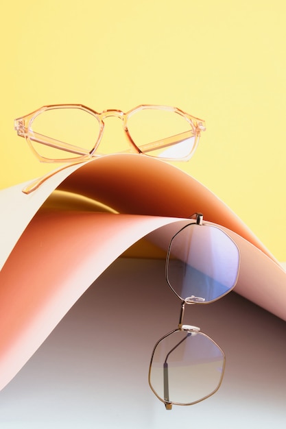 Foto mode trendy bril voor het corrigeren van visie op een creatieve achtergrond, golf van papier, kleurrijke achtergrond, kopieer ruimte