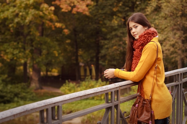 Mode vrouw op brug in herfst park