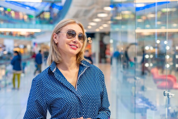 Mode winkelen meisje portret. Schoonheid vrouw met boodschappentassen in winkelcentrum. Shopper. Verkoop.