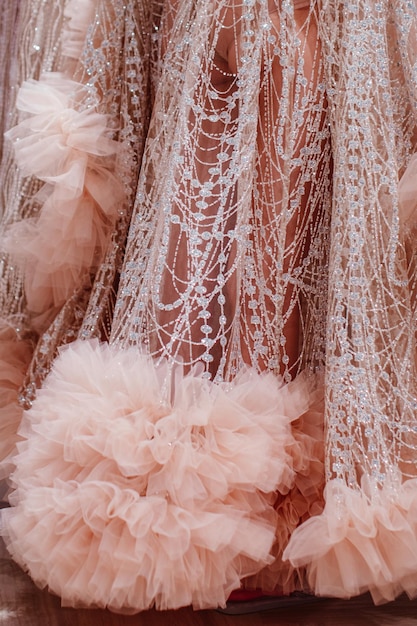 Foto modedetails van een pluizige lange roze haute couture boudoir jurk met glitter mode shot