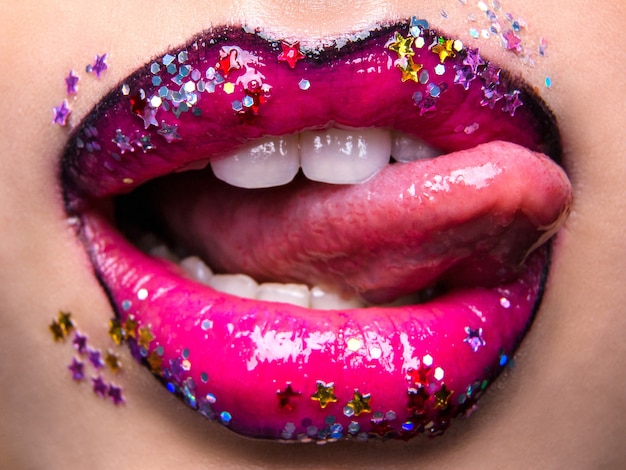 Foto modefoto mooie rode lippen lippenstift en lipgloss sterren rond de mond uitpuilende tong