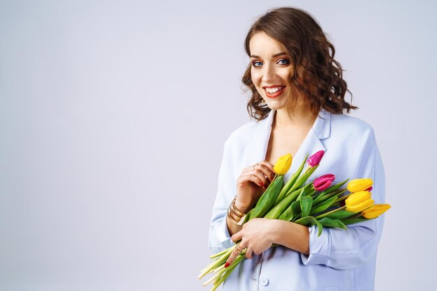 Modefoto van een mooie vrouw met tulpen in haar handen Lenteconcept 8 maart