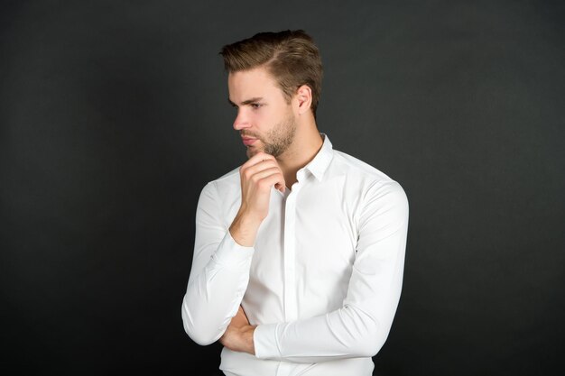 Modekapper Ernstige man aanraking baard donkere achtergrond Baardkapper Knappe jongen met ongeschoren gezicht Herenverzorging Huidverzorging en haarverzorging Kapperszaak Kappersdiensten Kapperszaak en kapsalon