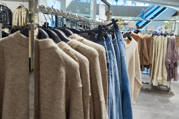 Modekleding die aan hangers hangt in een trendy moderne winkel