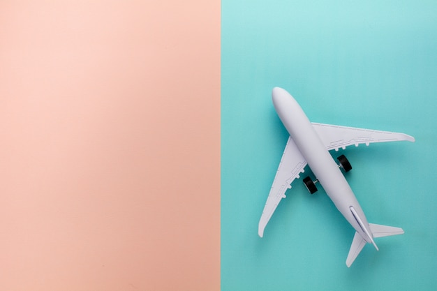 Aeroplano di modello sul fondo di colore pastello rosa e blu.