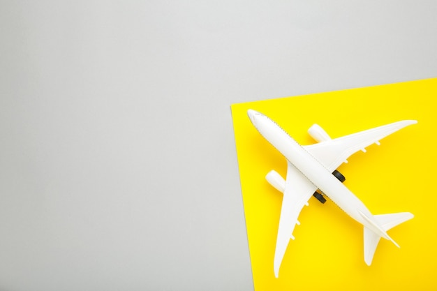 Model airplane on yellow and grey wall. Travel concept