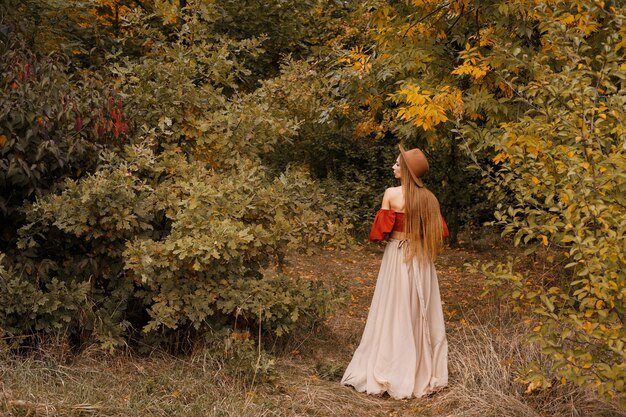 Model in autumn clothes on an autumn background in the forest. free space for text