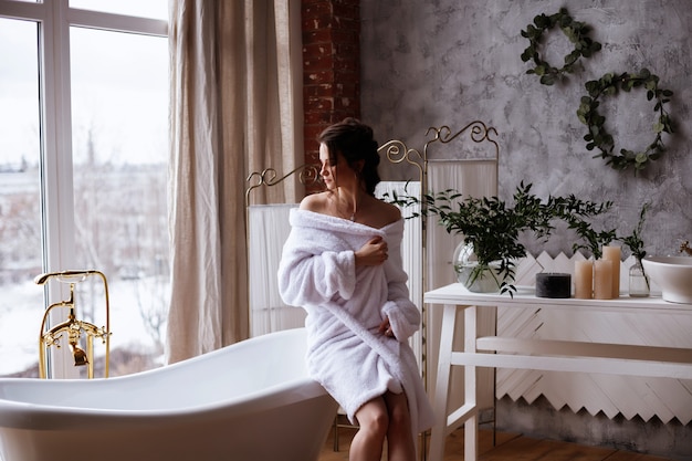 Photo model in a bathrobe in the bathroom