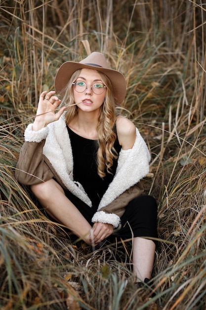 Model in black dress in dry grass