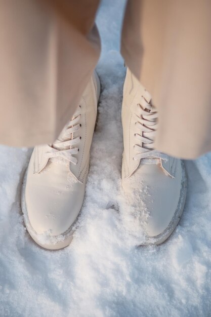 The model demonstrates women's shoes standing in the snow