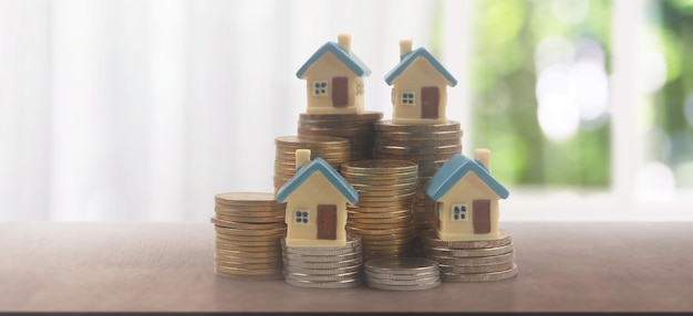 Model of detached miniature house mock and coins property real estate investment concept