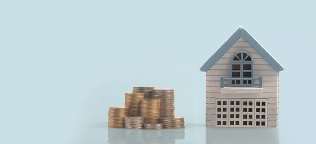 분리된 미니어처 하우스의 모델은 동전을 조롱합니다. 부동산 부동산 투자 개념