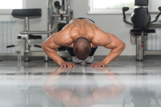 Photo model doing press ups in gym