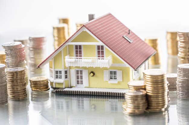 Model familly house with coins as bank or insurance concept.