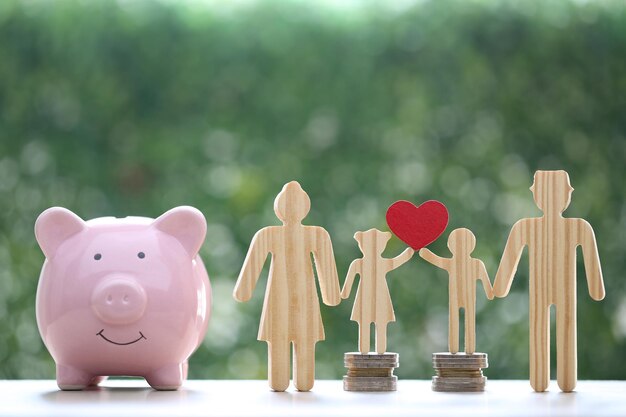 Photo model family with piggy bank and stack of coins money on natural green backgroundsave money for prepare in future and family finance concept