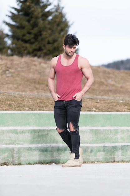 Model Flexing Muscles Outdoors in Nature