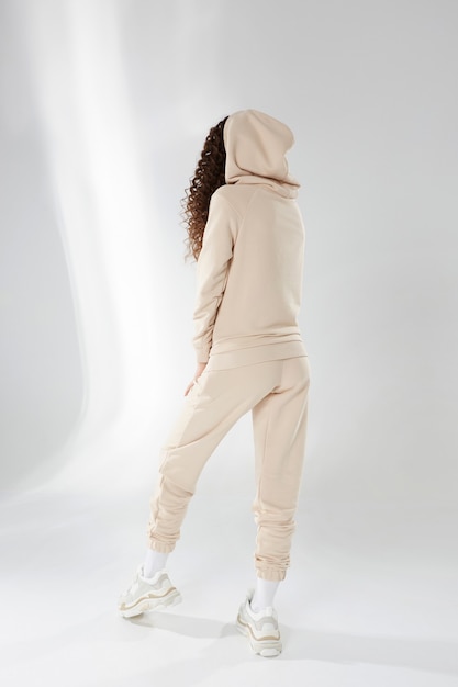 Модель девушки со стройным спортивным телом в модной спортивной одежде на белом фоне копировальное пространство