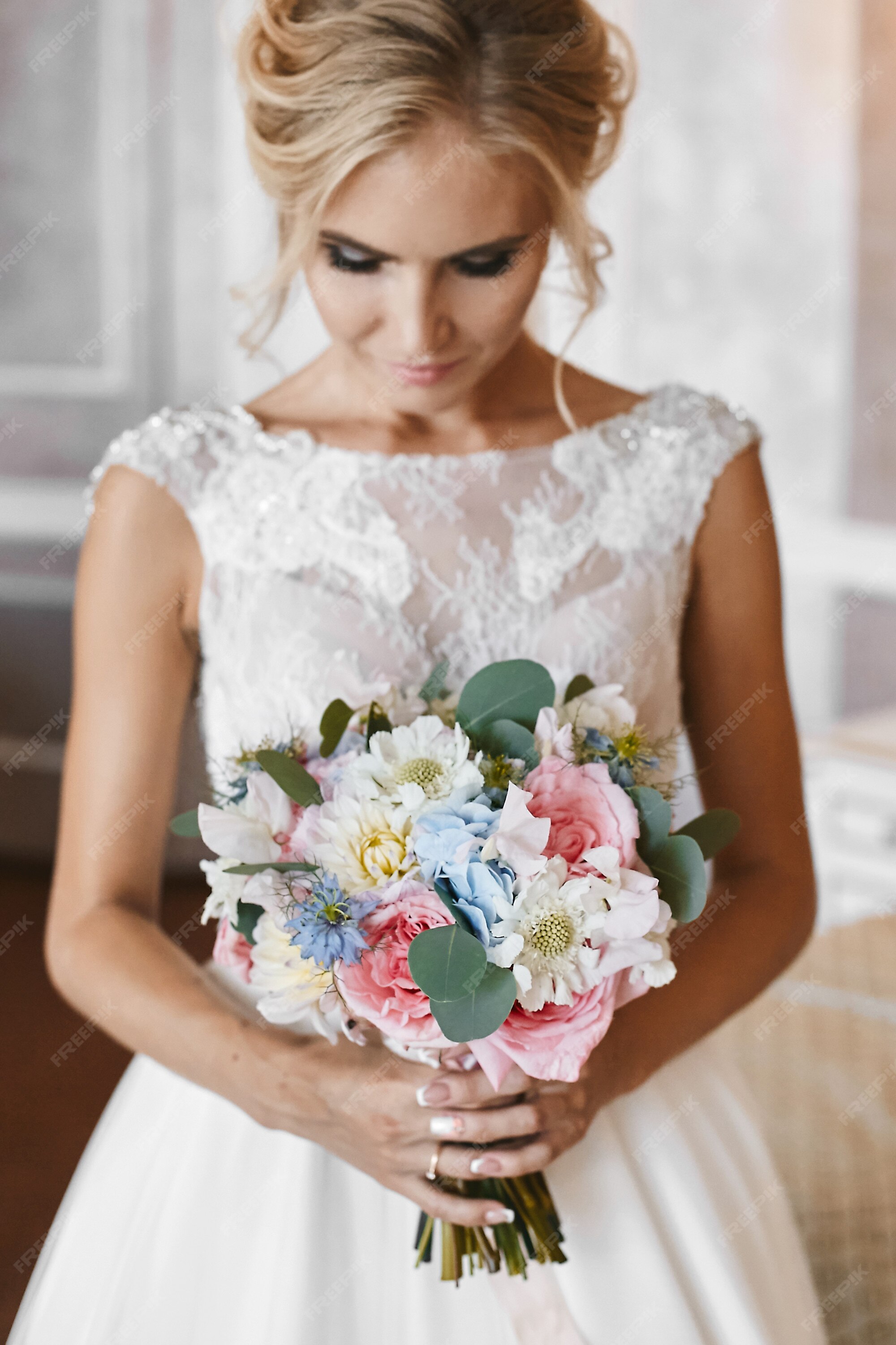 Premium Photo | Model girl with wedding hairstyle and right makeup in lace white dress with the big luxury bouquet of exotic flowers in her hands posing at interior Premium Photo | Model girl with wedding hairstyle and right makeup in lace white dress with the big luxury bouquet of exotic flowers in her hands posing at interior