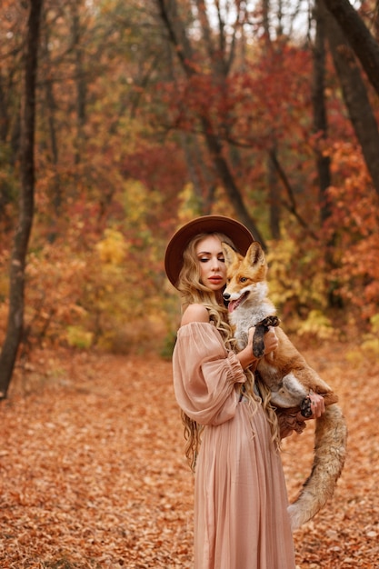 Model holding a fox in a forest