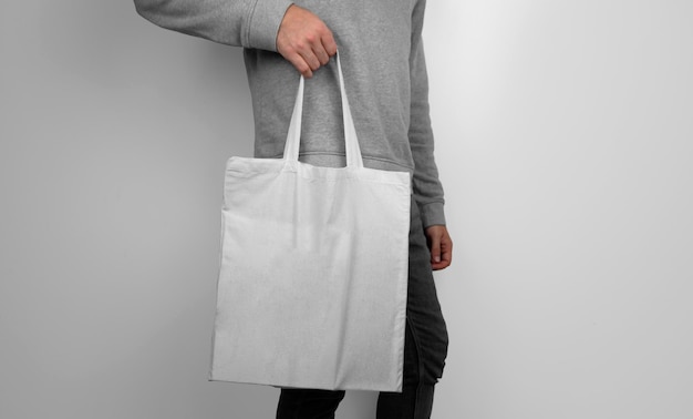 Model holding a white tote bag