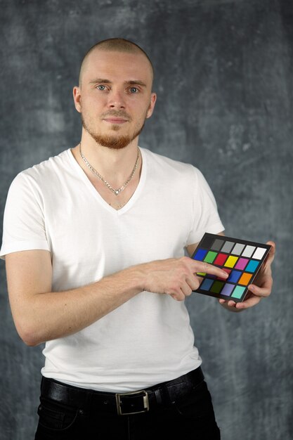 The model holds a color checker card.