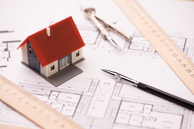 A model house on blueprints with keys to the new home Close up