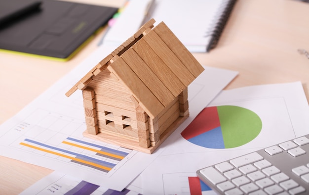 Model house and calculator on construction plan