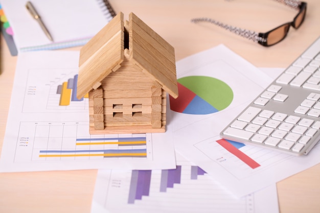 Model house and calculator on construction plan