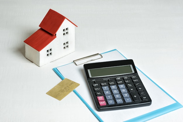 Model of house, credit card and calculator on. Buying a home. Concept of mortgage and real estate.