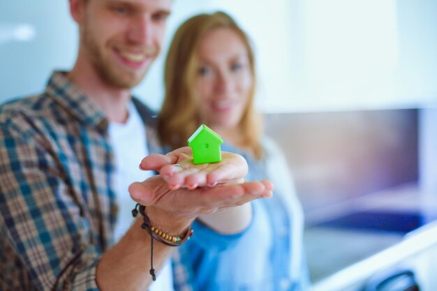 Model house in hand of a couple standing in new home model house