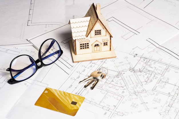 Model of a house and key ring plan project and drawings on paper with copy space