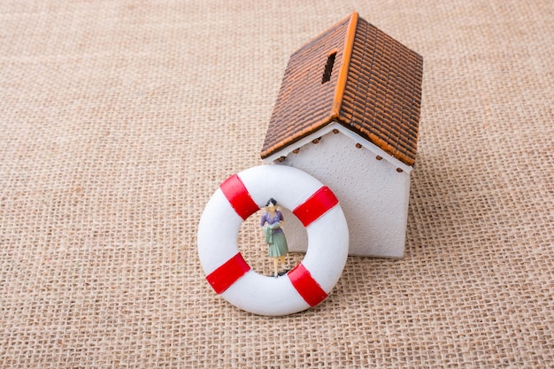 Model house and a life preserver with a woman figure
