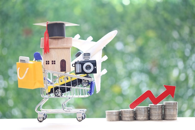 Model house or property on model miniature shopping cart and red arrow graph on green background