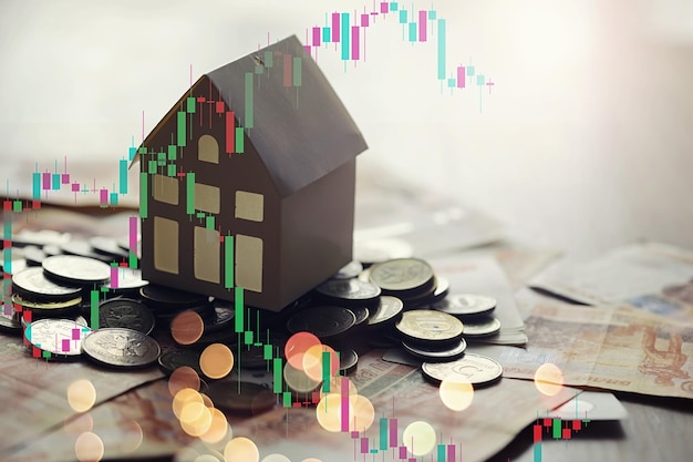 The model of the house standing on five thousand ruble denominations and keys with a key in the form of a house a concept on the topic of highpriced mortgage loans in Russia