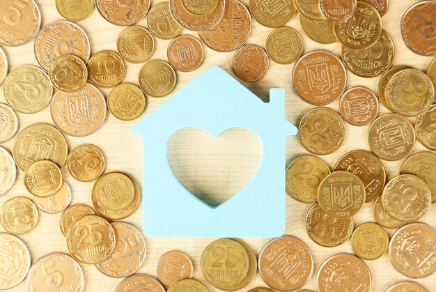 Model of house with coins on table close up