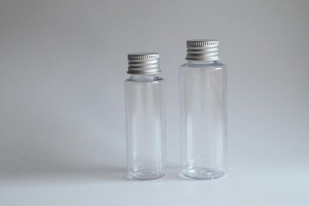 Photo model image of clear glass bottle with metal lid on white backgroundmockup