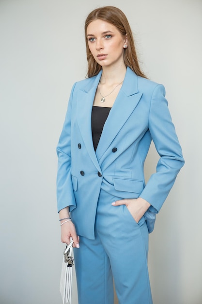 The model is a girl in a blue business suit Shooting fashionable clothes for the store Studio background