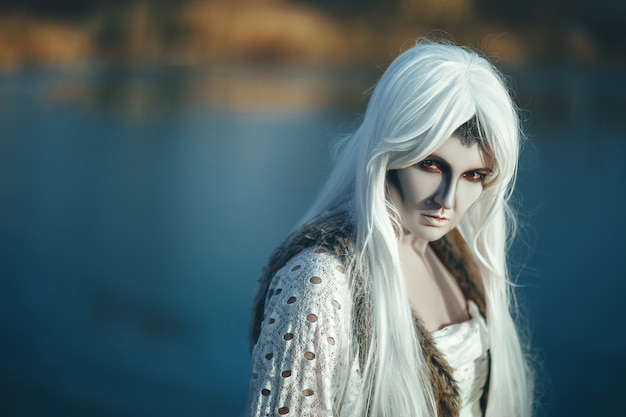 Model is posing on an icy lake with a creative makeup