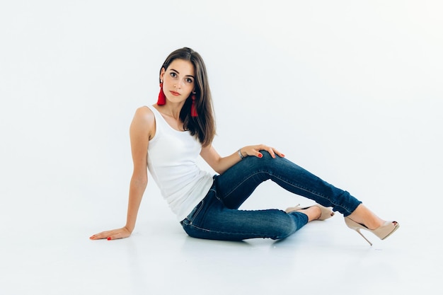 Model jong meisje in een wit T-shirt en een blauwe spijkerbroek