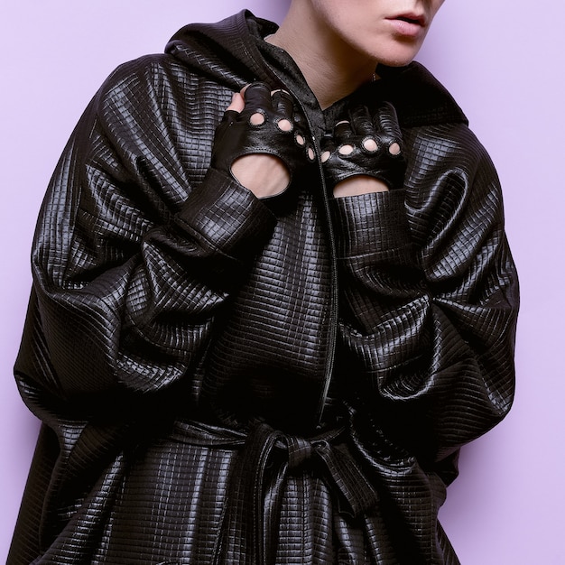Модель длинного черного пальто и перчаток модный тренд сезона