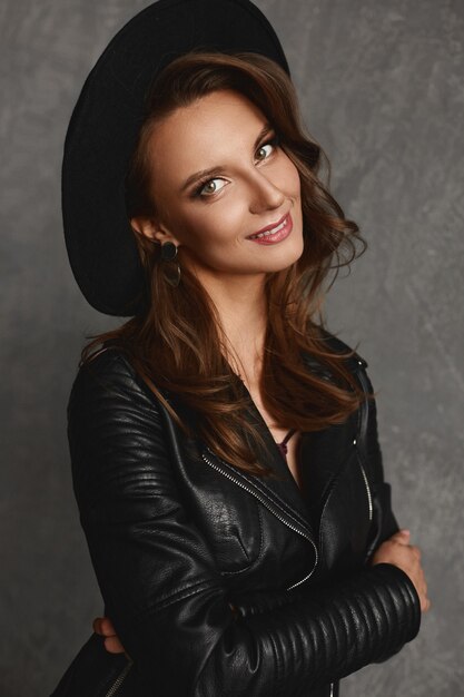 Model meisje in stijlvolle hoed en leren jas
