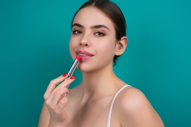 Model meisje lippenstift houden over kleur studio achtergrond schoonheid vrouw gezicht cosmetica make-up mode