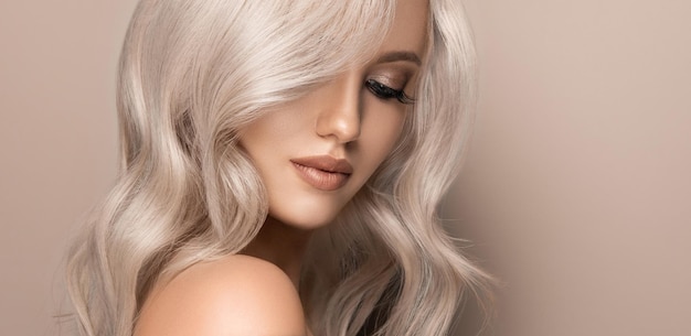 Model met geverfd blond haar en gekleed in heldere avondmake-up Hairstyling haarverf