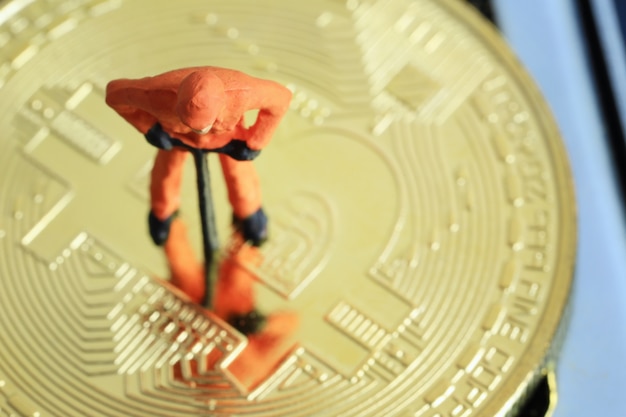 Foto le persone modello dei minatori sono in piedi sul bitcoin d'oro.