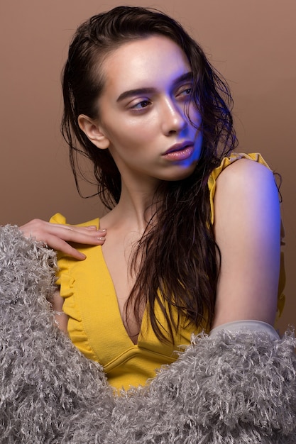 Model posing on the beige under the blue light.