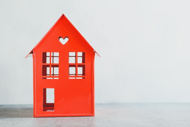 Model red house on table against wall