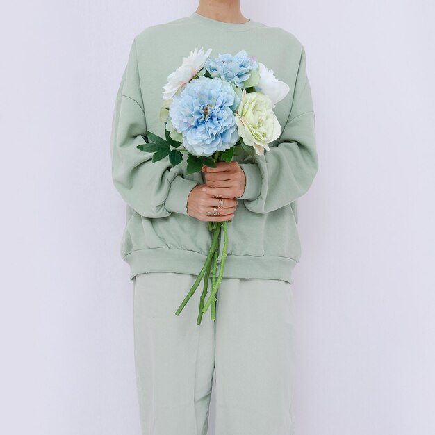 Model Standing In white Room with Flowers In Her Hands