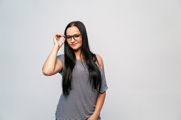 Model stands in a striped dress and in stylish eyeglasses 