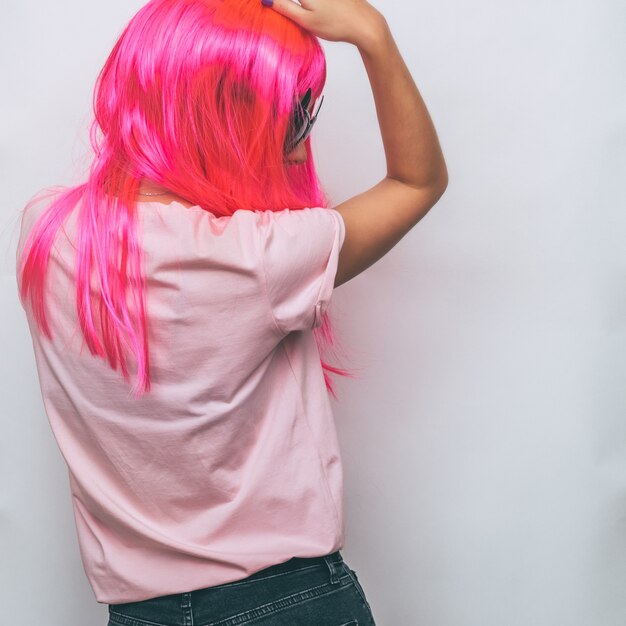 Model stands with her back in pink wig