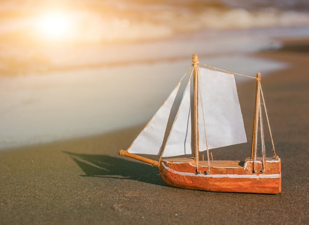 Foto model van een zeilschip gemaakt van houten papier op de kust kinderspeelgoed hobby's